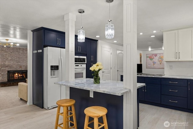 18020 SE 146th St, Renton, WA 98059 - kitchen with white appliances, blue cabinetry, light wood-style floors, a kitchen bar, and recessed lighting