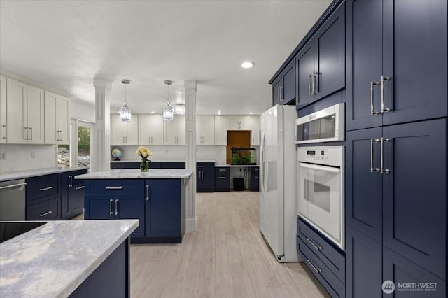 18020 SE 146th St, Renton, WA 98059 - kitchen featuring stainless steel appliances, light countertops, light wood-style floors, white cabinetry, and blue cabinetry