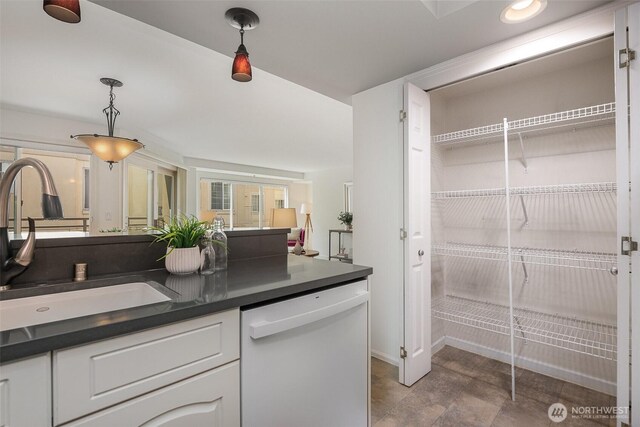 11011 NE 12th St Unit 501, Bellevue, WA 98004 - kitchen with white dishwasher, dark countertops, white cabinets, and hanging light fixtures