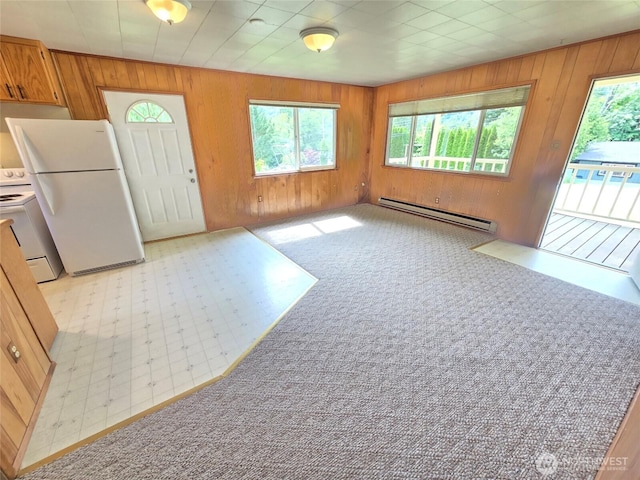 362 Lakeside Dr, Sedro Woolley, WA 98284 - kitchen featuring baseboard heating, white appliances, plenty of natural light, wooden walls, and brown cabinets