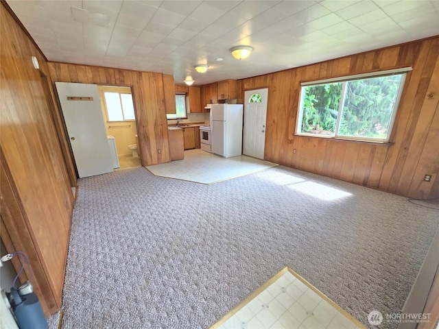 362 Lakeside Dr, Sedro Woolley, WA 98284 - kitchen featuring white appliances, brown cabinets, wood walls, light carpet, and open floor plan