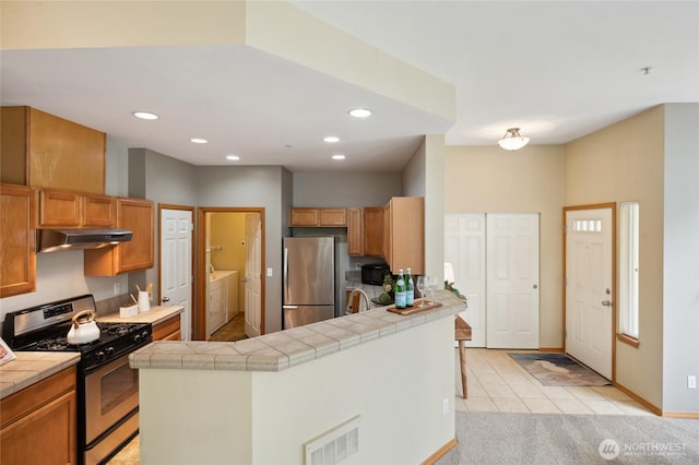 1855 Trossachs Blvd SE Unit 2002, Sammamish, WA 98075 - kitchen featuring appliances with stainless steel finishes, under cabinet range hood, washer and dryer, tile countertops, and recessed lighting