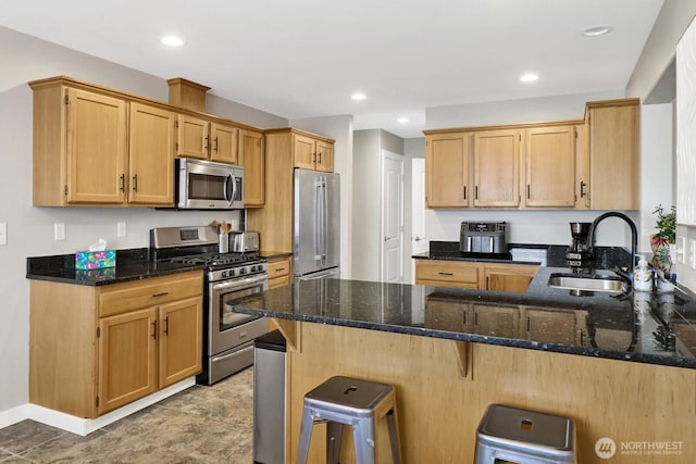 8419 Double Ditch Rd, Lynden, WA 98264 - kitchen featuring appliances with stainless steel finishes, a peninsula, dark stone counters, a kitchen bar, and recessed lighting