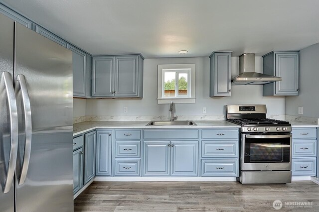 1942 Trigg Rd Unit 38, Ferndale, WA 98248 - kitchen featuring appliances with stainless steel finishes, wall chimney range hood, light countertops, gray cabinetry, and light wood-type flooring