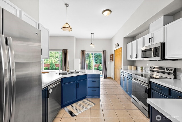 209 Groff Ave NW, Orting, WA 98360 - kitchen with appliances with stainless steel finishes, a peninsula, white cabinets, light countertops, and blue cabinetry