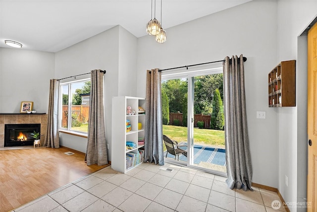 209 Groff Ave NW, Orting, WA 98360 - unfurnished dining area with plenty of natural light, a tiled fireplace, and light tile patterned floors