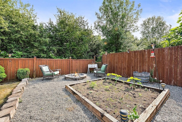 209 Groff Ave NW, Orting, WA 98360 - fenced backyard with an outdoor fire pit and a vegetable garden