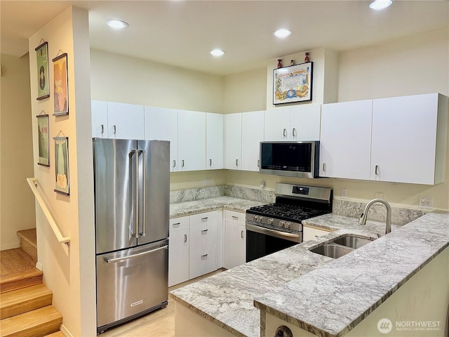 4714 Fairwood Blvd NE Unit 201, Tacoma, WA 98422 - kitchen with stainless steel appliances, a peninsula, light stone countertops, light wood-type flooring, and recessed lighting