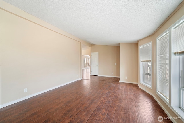 1303 Craig St W, Moses Lake, WA 98837 - empty room featuring healthy amount of natural light, dark wood-style flooring, and a textured ceiling