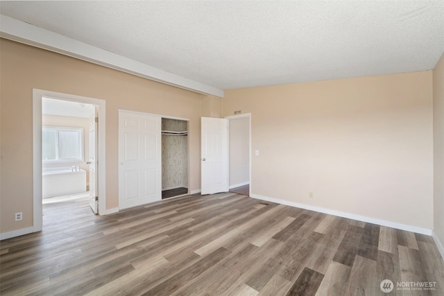 1303 Craig St W, Moses Lake, WA 98837 - unfurnished bedroom featuring wood finished floors, a closet, a textured ceiling, and ensuite bathroom
