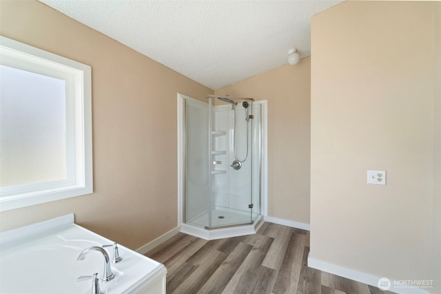 1303 Craig St W, Moses Lake, WA 98837 - bathroom with a shower stall, wood finished floors, a bath, vaulted ceiling, and a textured ceiling