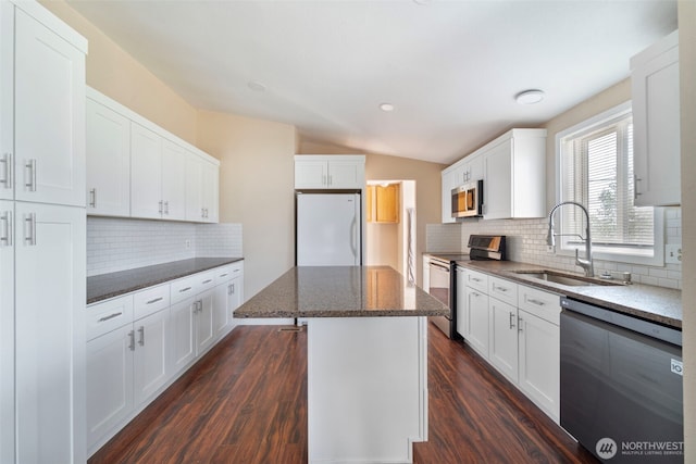 1303 Craig St W, Moses Lake, WA 98837 - kitchen with stainless steel appliances, decorative backsplash, a center island, vaulted ceiling, and dark wood-style floors