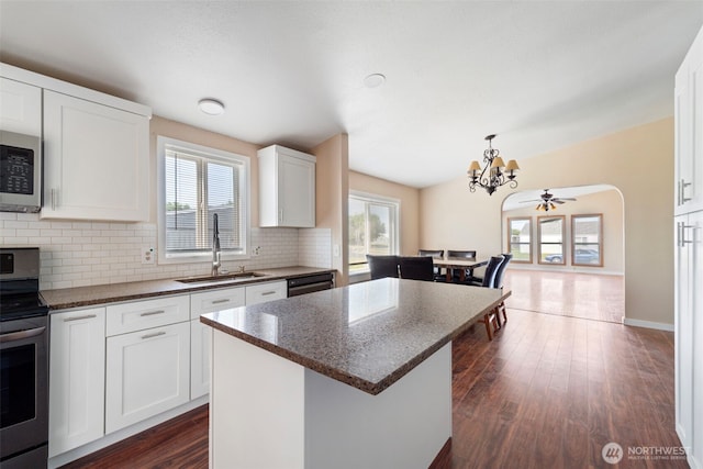 1303 Craig St W, Moses Lake, WA 98837 - kitchen featuring appliances with stainless steel finishes, a chandelier, decorative backsplash, a center island, and dark wood-style flooring