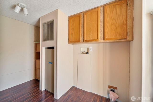 1303 Craig St W, Moses Lake, WA 98837 - laundry area with cabinet space, dark wood-type flooring, a textured ceiling, and washer hookup