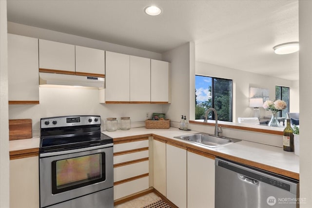 3256 SW Avalon St Unit 304, Seattle, WA 98126 - kitchen featuring appliances with stainless steel finishes, under cabinet range hood, light countertops, recessed lighting, and white cabinetry