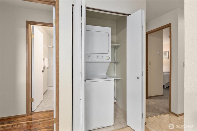 3256 SW Avalon St Unit 304, Seattle, WA 98126 - laundry area with stacked washer / drying machine and light tile patterned floors