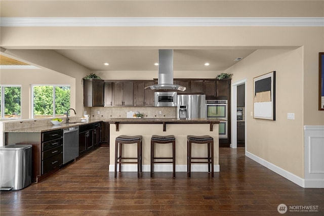 21230 SE 258th Pl, Maple Valley, WA 98038 - kitchen with appliances with stainless steel finishes, island exhaust hood, a kitchen bar, dark brown cabinetry, and tasteful backsplash