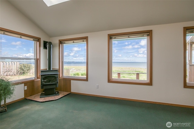 249 Burrows Rd, Hoquiam, WA 98550 - unfurnished living room with carpet floors, a wood stove, a water view, and vaulted ceiling