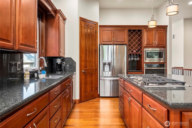 8003 113th Street Ct E, Puyallup, WA 98373 - kitchen featuring stainless steel appliances, light wood-type flooring, tasteful backsplash, pendant lighting, and a kitchen island