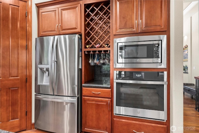 8003 113th Street Ct E, Puyallup, WA 98373 - kitchen with appliances with stainless steel finishes, dark countertops, and brown cabinets