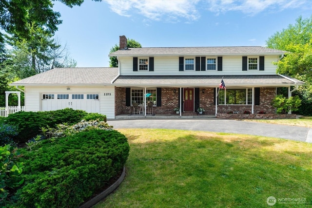1175 SW Lopez Dr, Oak Harbor, WA 98277 - traditional-style home featuring a chimney, asphalt driveway, a porch, an attached garage, and brick siding