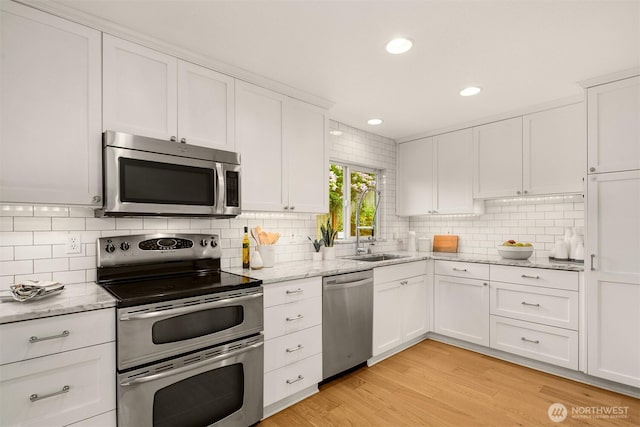 2441 NE 182nd St, Shoreline, WA 98155 - kitchen with stainless steel appliances, decorative backsplash, white cabinetry, light stone counters, and recessed lighting
