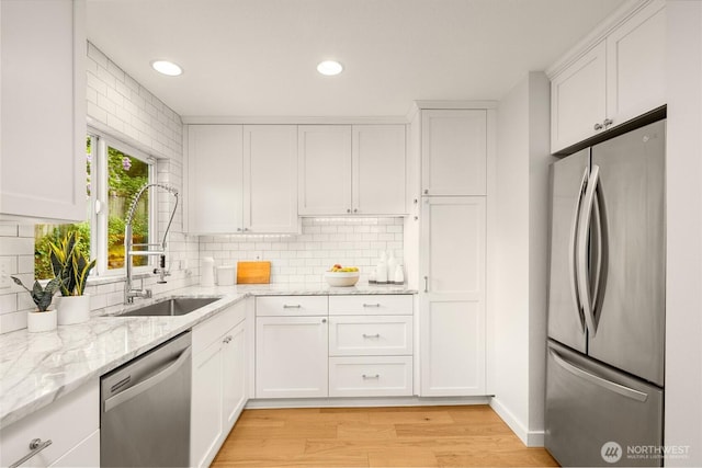 2441 NE 182nd St, Shoreline, WA 98155 - kitchen featuring stainless steel appliances, light wood finished floors, white cabinetry, decorative backsplash, and light stone countertops