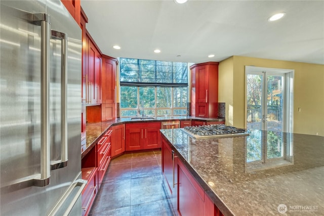 14329 SE 84th Ct, Newcastle, WA 98059 - kitchen featuring appliances with stainless steel finishes, reddish brown cabinets, recessed lighting, and dark stone countertops