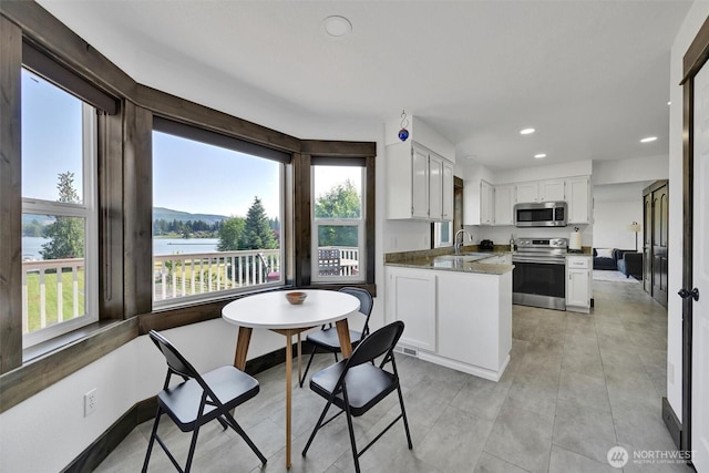17325 Topaz Loop SE, Yelm, WA 98597 - kitchen with stainless steel appliances, recessed lighting, white cabinetry, a peninsula, and a water view