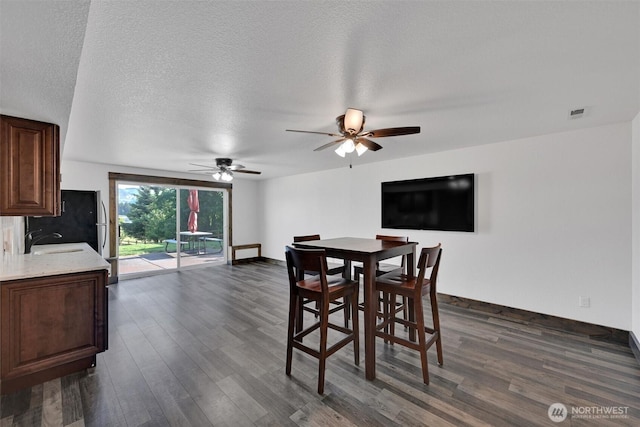 17325 Topaz Loop SE, Yelm, WA 98597 - dining area with dark wood-style floors, a ceiling fan, and a textured ceiling