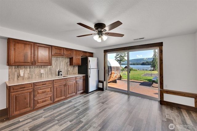 17325 Topaz Loop SE, Yelm, WA 98597 - kitchen with freestanding refrigerator, backsplash, light countertops, and light wood finished floors