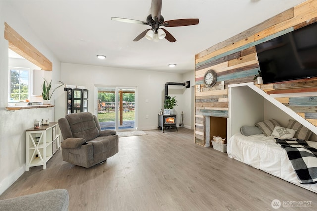 253 Kruger Rd Unit B, Onalaska, WA 98570 - living area featuring a ceiling fan, wood finished floors, a wood stove, and wood walls