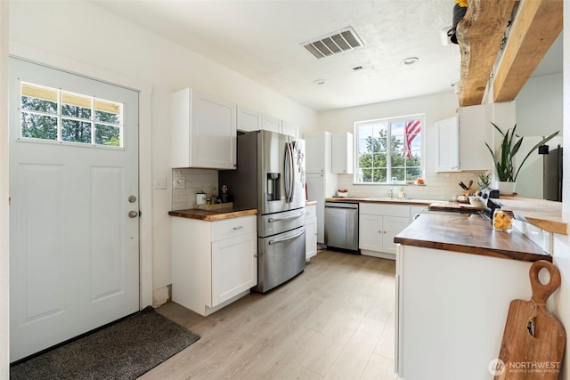 253 Kruger Rd Unit B, Onalaska, WA 98570 - kitchen with stainless steel appliances, light wood-type flooring, wood counters, decorative backsplash, and white cabinets
