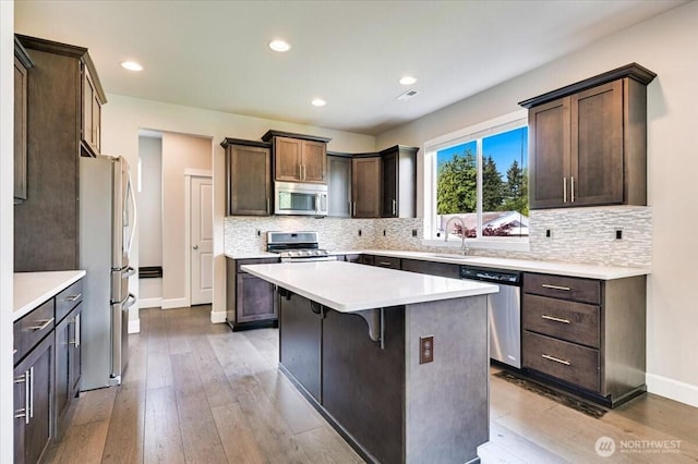 16311 5th Dr SE, Bothell, WA 98012 - kitchen featuring stainless steel appliances, dark brown cabinets, light wood-type flooring, tasteful backsplash, and recessed lighting