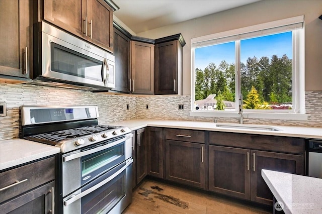 16311 5th Dr SE, Bothell, WA 98012 - kitchen featuring stainless steel appliances, light countertops, dark brown cabinets, and backsplash