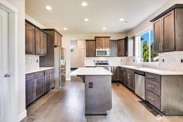 16311 5th Dr SE, Bothell, WA 98012 - kitchen with appliances with stainless steel finishes, a kitchen island, tasteful backsplash, recessed lighting, and light countertops
