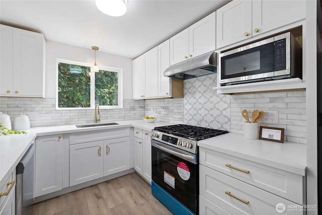 824 SW 301st Pl, Federal Way, WA 98023 - kitchen with stainless steel appliances, under cabinet range hood, decorative backsplash, and white cabinets