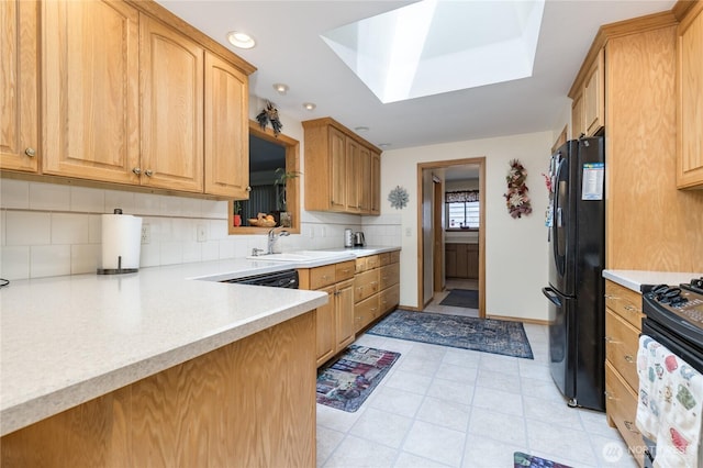 1023 E Maple St, Kent, WA 98030 - kitchen with black appliances, light countertops, tasteful backsplash, a skylight, and recessed lighting