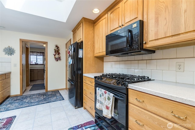 1023 E Maple St, Kent, WA 98030 - kitchen featuring black appliances, light countertops, decorative backsplash, a skylight, and light tile patterned floors
