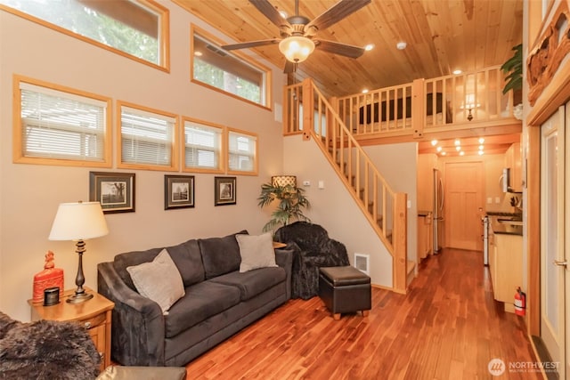 1546 Reservation Rd SE Unit 213, Olympia, WA 98513 - living room featuring wood ceiling, a towering ceiling, wood finished floors, ceiling fan, and stairs