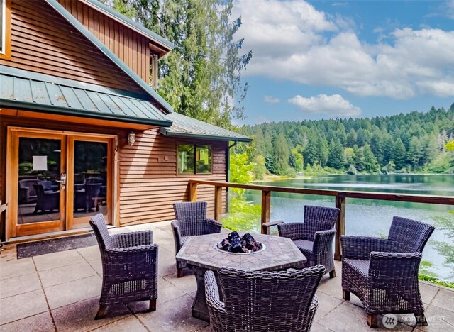 1546 Reservation Rd SE Unit 213, Olympia, WA 98513 - view of patio featuring a view of trees, a water view, an outdoor fire pit, and french doors
