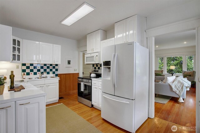 2433 E Valley St, Seattle, WA 98112 - kitchen with white appliances, light wood-style floors, light countertops, white cabinetry, and glass insert cabinets