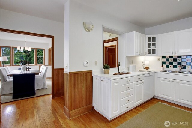 2433 E Valley St, Seattle, WA 98112 - kitchen featuring dishwasher, wainscoting, glass insert cabinets, light wood finished floors, and a chandelier