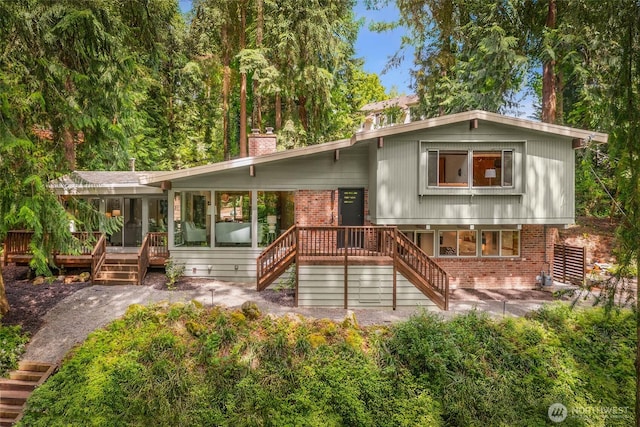 14460 NE 16th Pl, Bellevue, WA 98007 - rear view of house featuring stairway, a sunroom, brick siding, and a deck