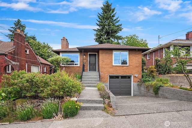 4886 24th Ave S, Seattle, WA 98108 - view of front of home featuring concrete driveway, a garage, a chimney, and brick siding