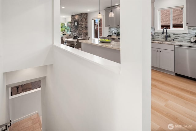 4886 24th Ave S, Seattle, WA 98108 - kitchen with dishwasher, backsplash, light stone countertops, light wood-type flooring, and recessed lighting