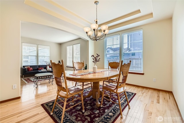 3205 179th Pl SE, Bothell, WA 98012 - dining room featuring a chandelier, light wood-style floors, a raised ceiling, and arched walkways