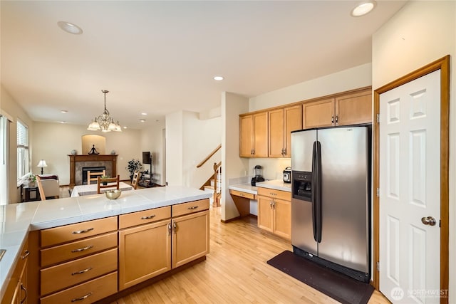 3205 179th Pl SE, Bothell, WA 98012 - kitchen with stainless steel fridge with ice dispenser, light wood-type flooring, a fireplace, tile countertops, and recessed lighting