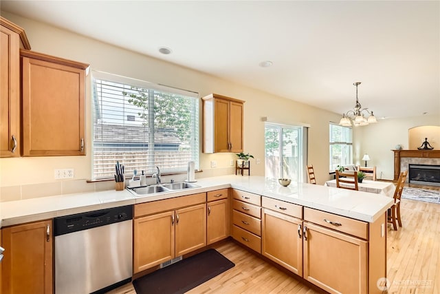 3205 179th Pl SE, Bothell, WA 98012 - kitchen with stainless steel dishwasher, a peninsula, light wood-style floors, a chandelier, and light countertops