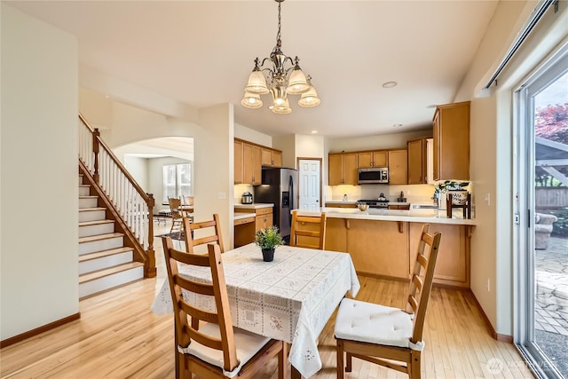 3205 179th Pl SE, Bothell, WA 98012 - dining space with a chandelier, light wood finished floors, arched walkways, stairway, and recessed lighting